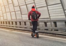 Mężczyzna na elektrycznej hulajnodze na autostradzie