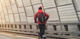 Mężczyzna na elektrycznej hulajnodze na autostradzie