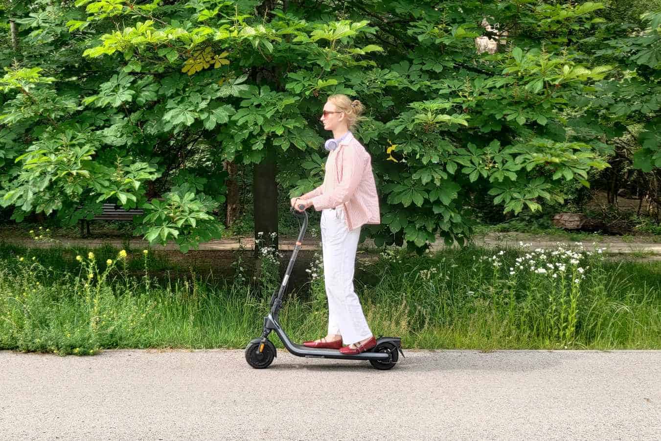 Dziewczyna jadąca na hulajnodze elektrycznej drogą dla rowerów
