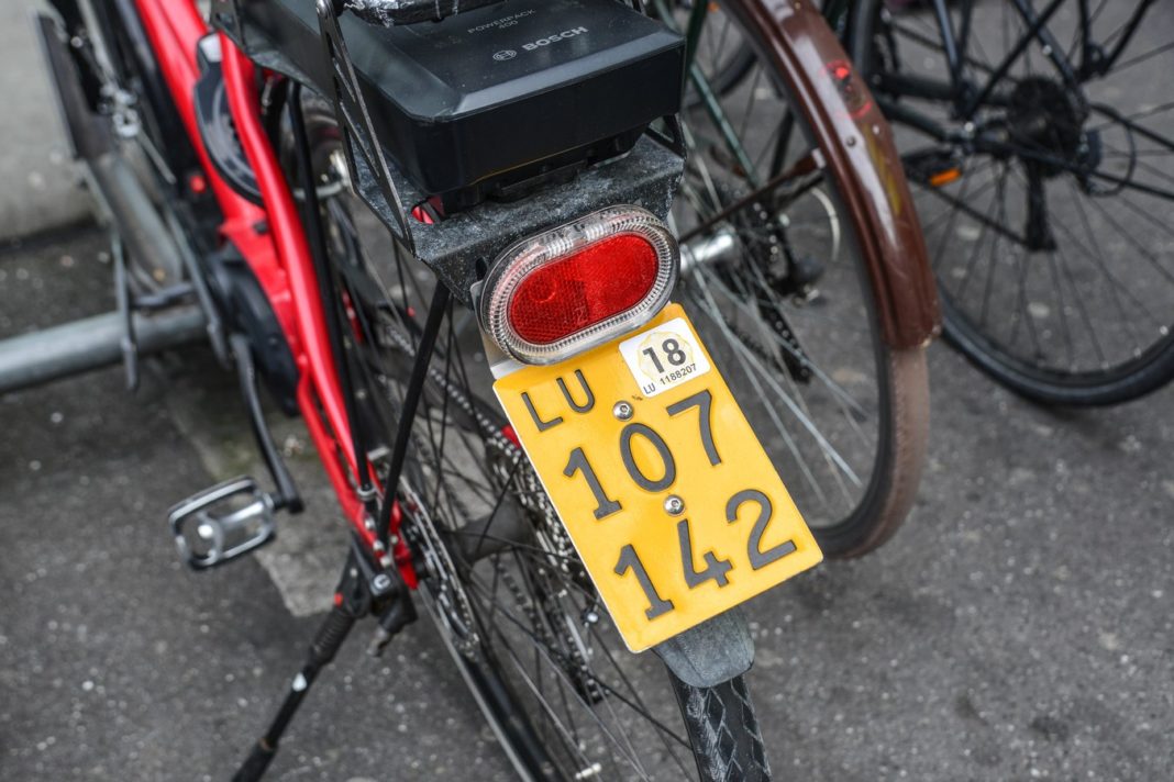 Bicycles parked on the city street Rower elektryczny z tablicą rejestracyjną