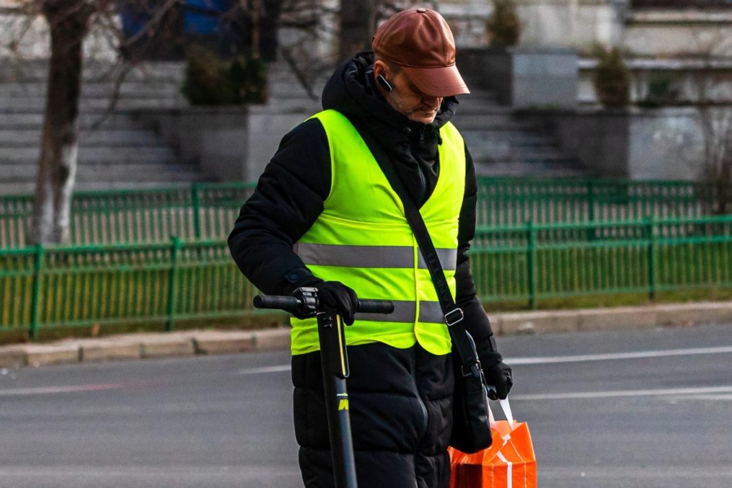 Man walking next to a electric scooter in Bucharest, Romania, 2022 Irlandia wprowadza nowe przepisy regulujące elektryczne hulajnogi